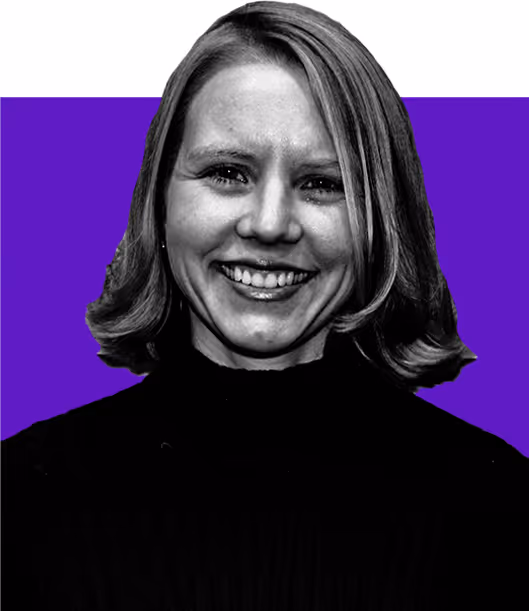 Smiling woman with shoulder-length hair wearing a black turtleneck against a purple and white background.