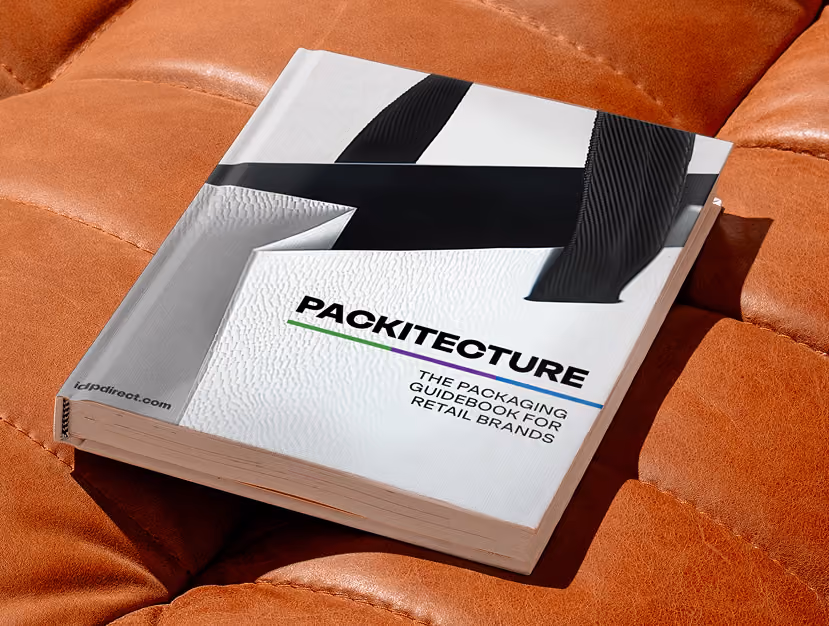 Book titled Packitecture: The Packaging Guidebook for Retail Brands resting on a brown leather surface.