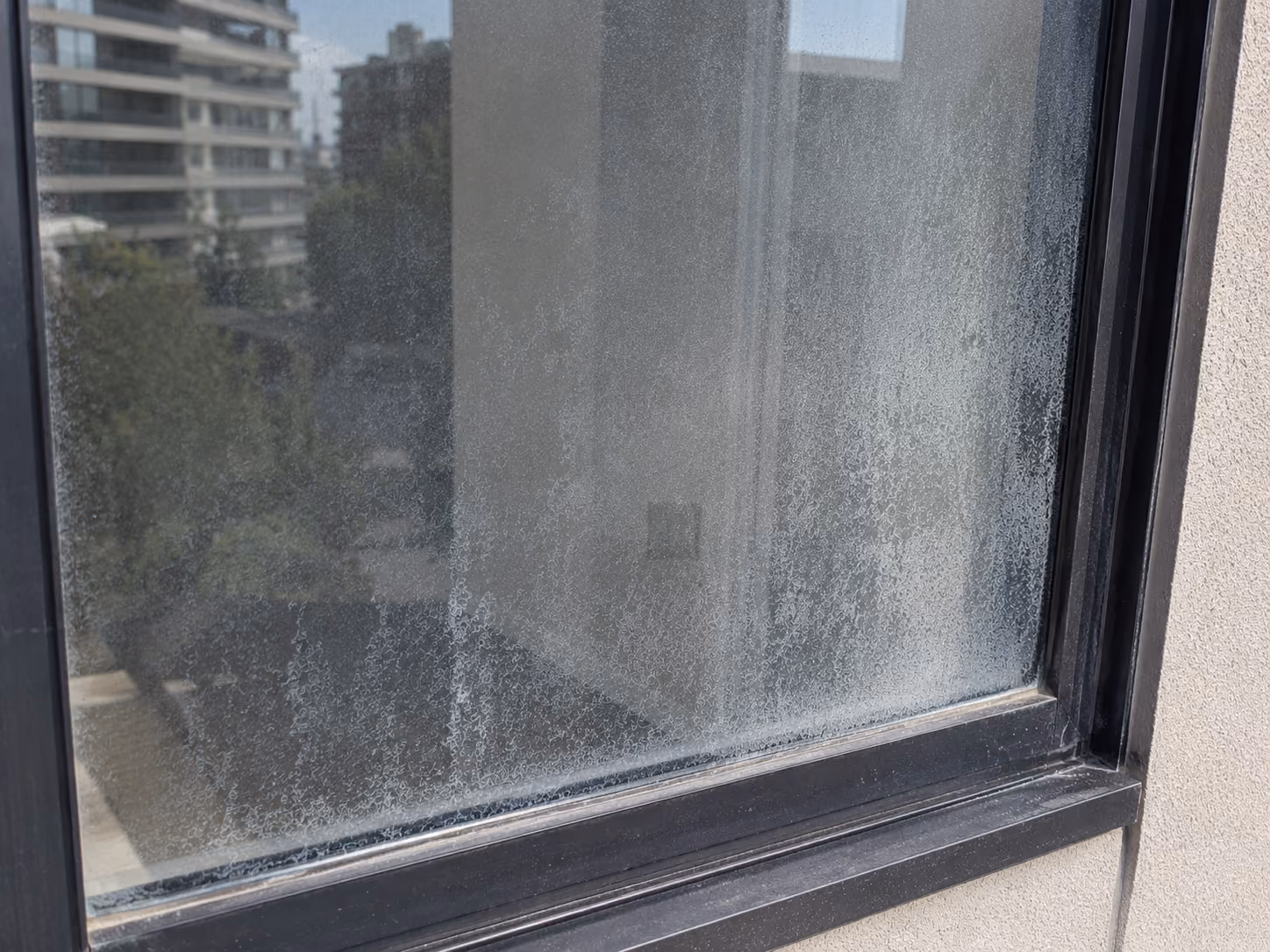 Corroding steel reinforcement bar exposed along the edge of a concrete balcony slab