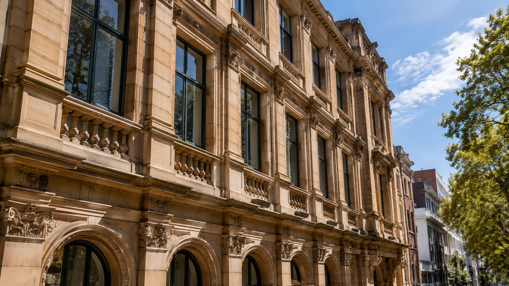 Ornate sandstone heritage building facade with balustrades and arched windows