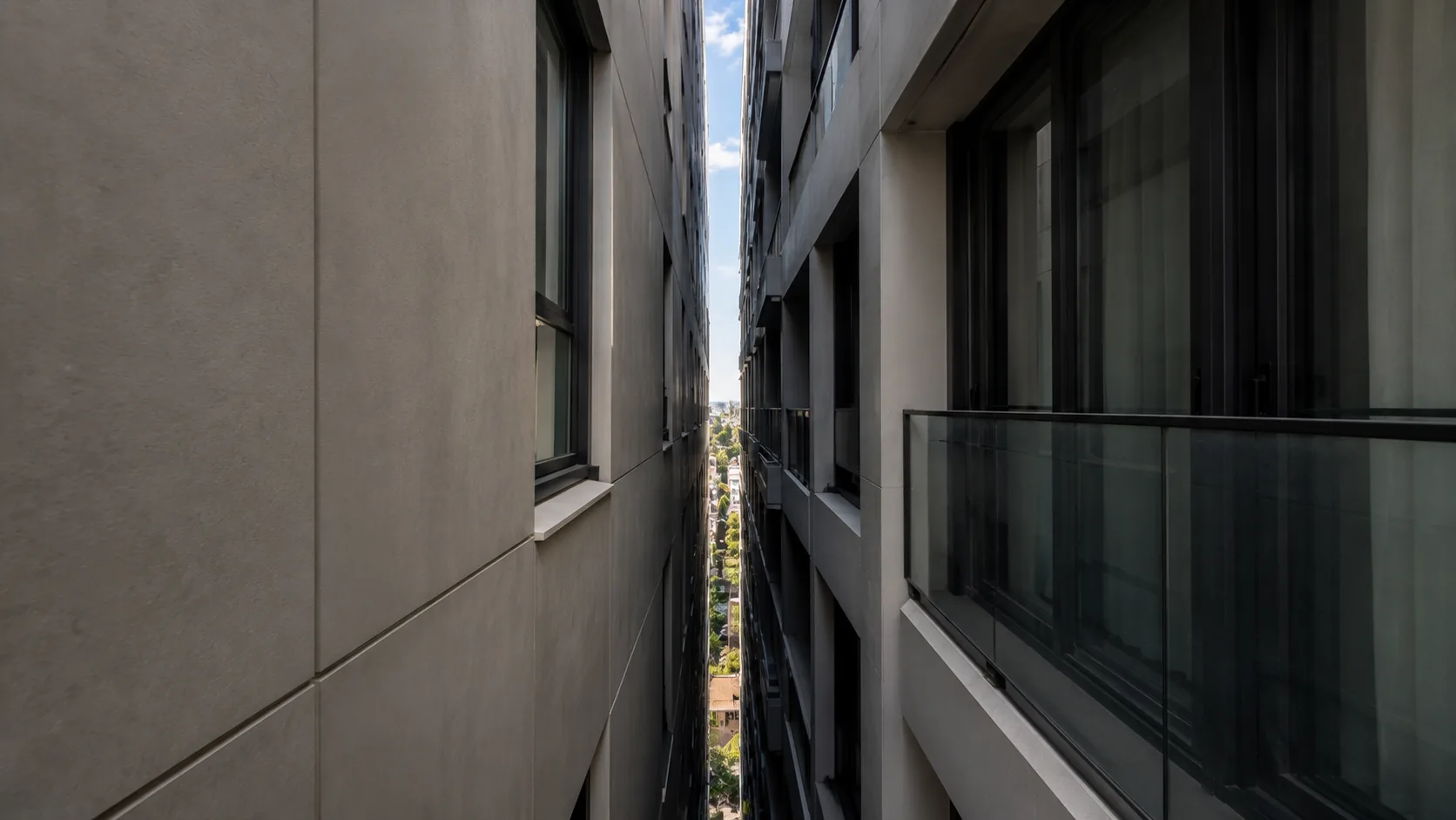 Narrow gap between two apartment buildings showing tight vertical access