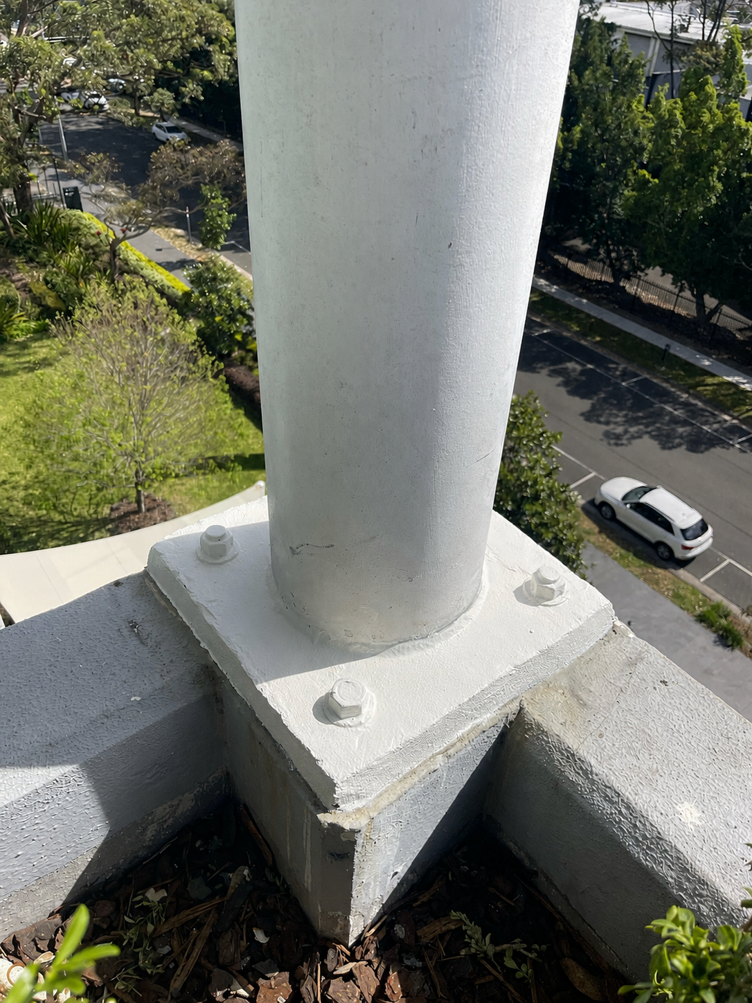 Steel column baseplate primed and painted white after rope-access remedial coating, Sydney