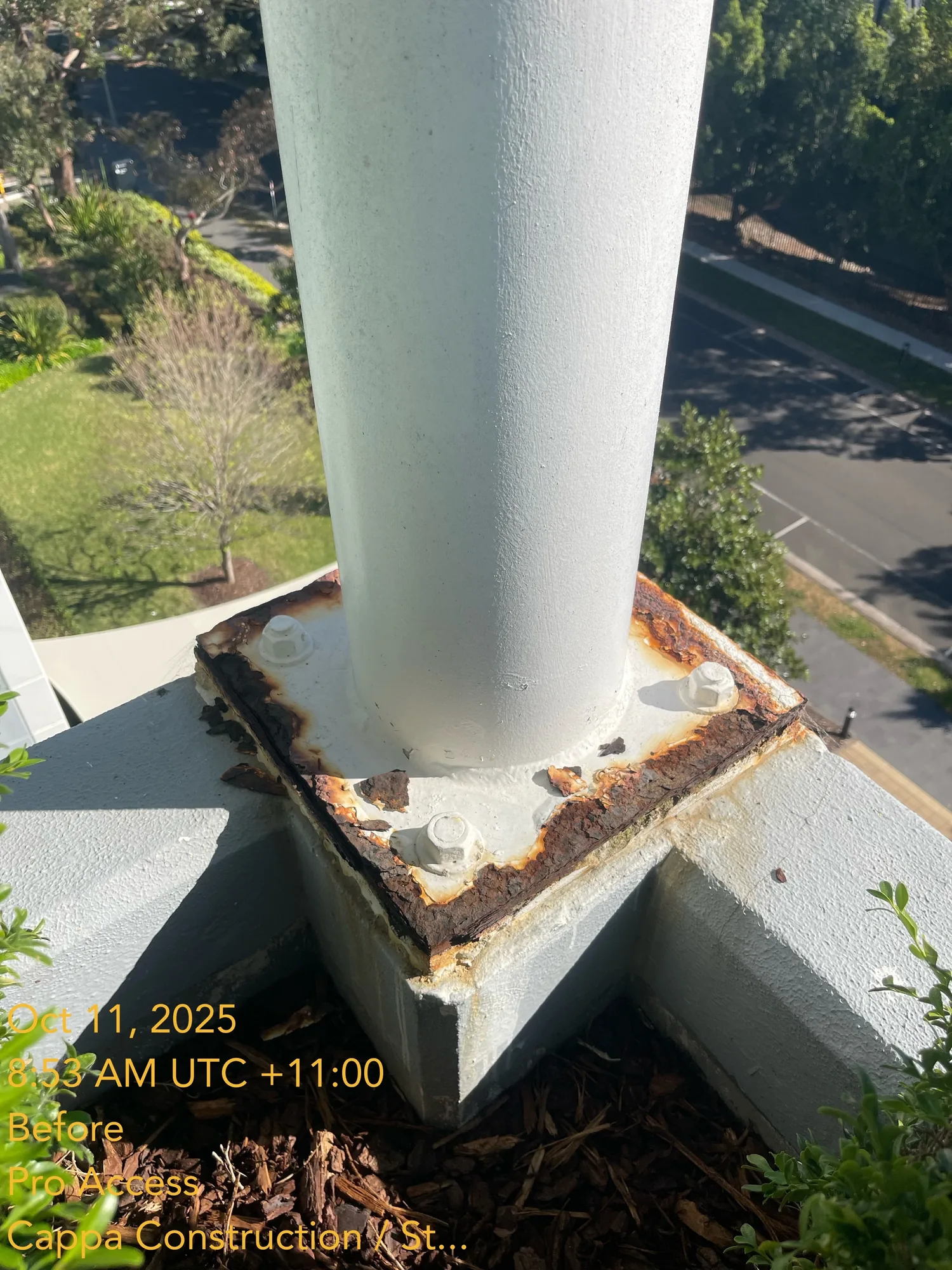 Steel column baseplate with rust bleeding through paint before remedial coating, Sydney