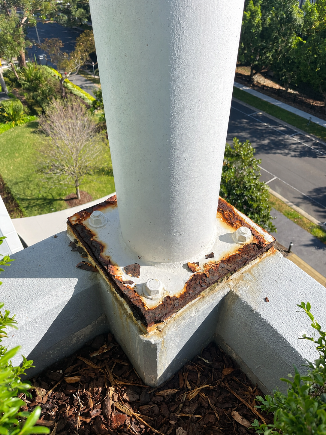 Steel column baseplate with rust bleeding through paint before remedial coating, Sydney