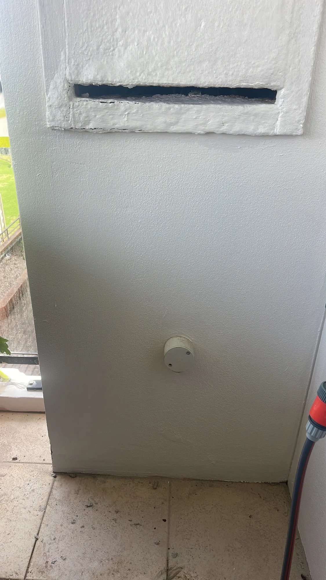 Balcony wall re-rendered and repainted after remedial repair, with vent reveal made good