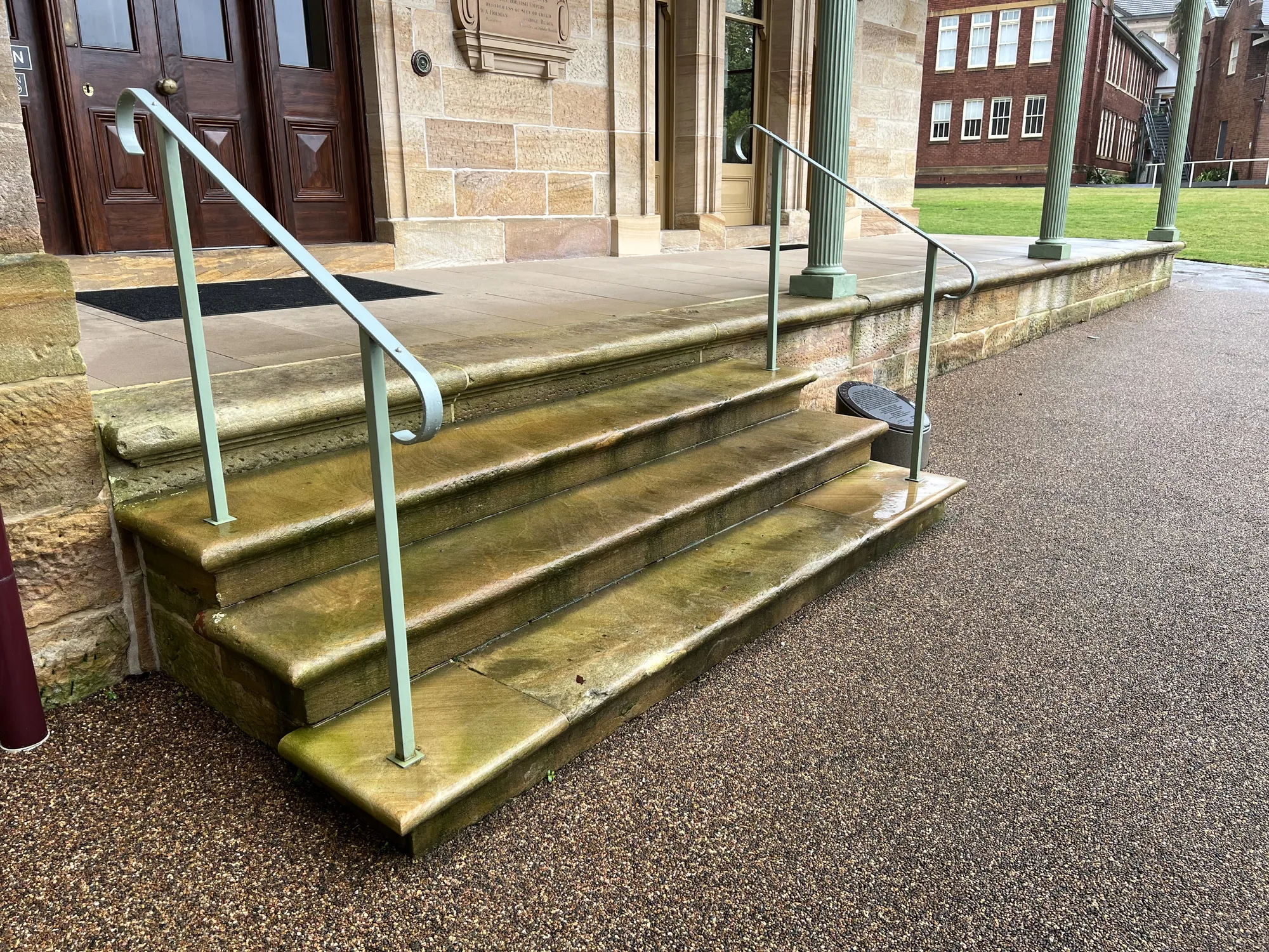 Heritage sandstone steps stained green with algae before soft-wash cleaning, Sydney
