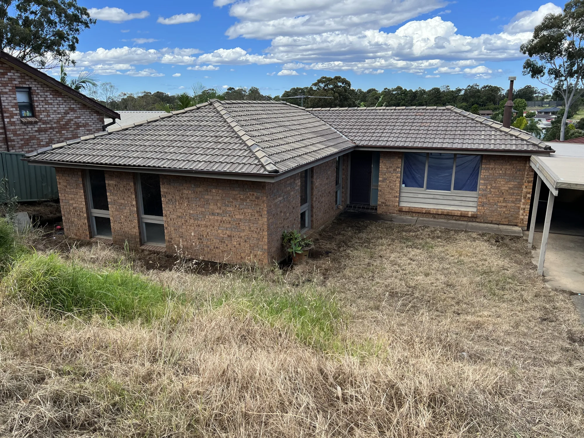 Weathered concrete-tile hip roof on a brick home after cleaning, before roof painting, Western Sydney