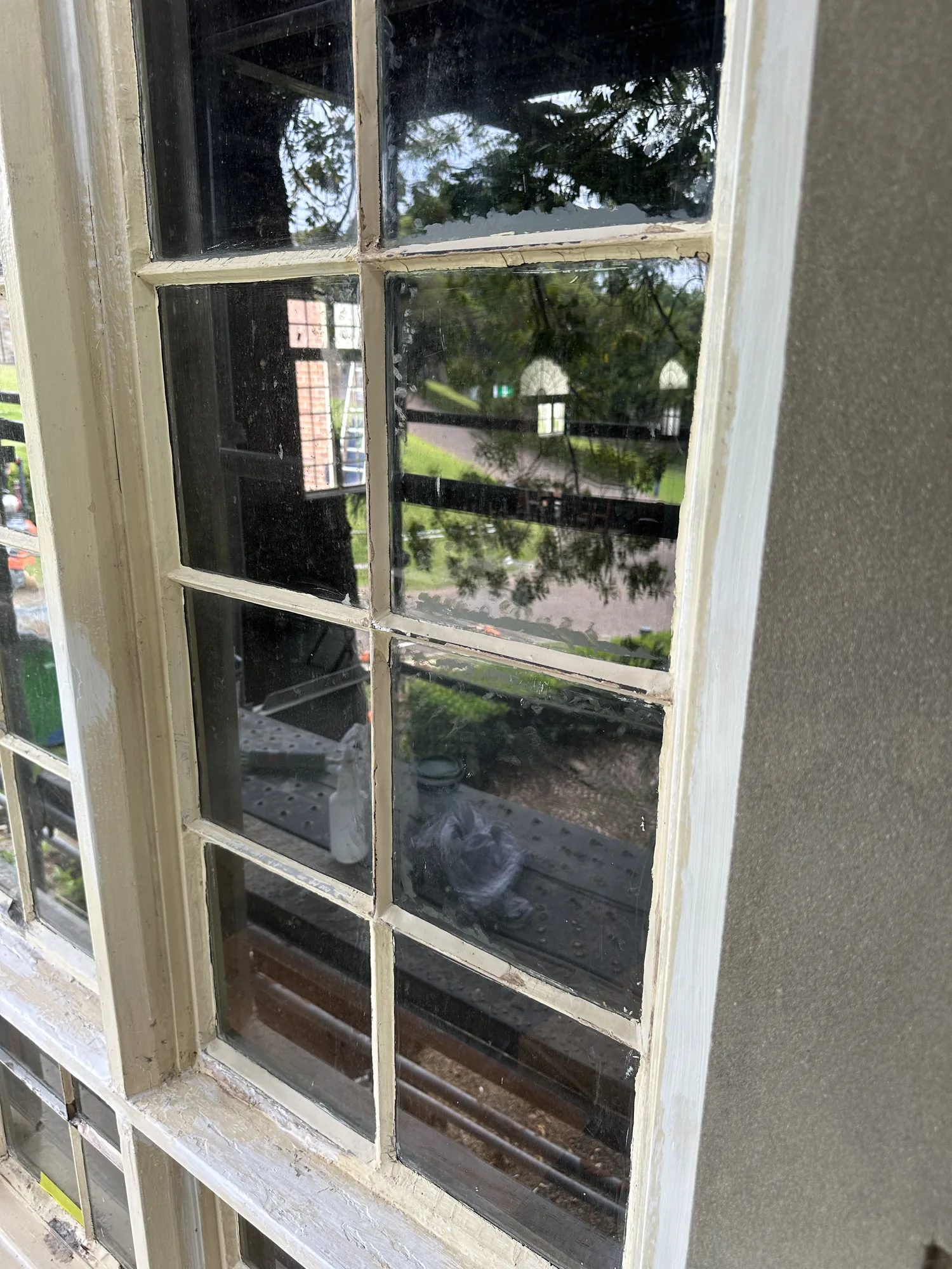 Heritage timber multi-pane window re-puttied and repainted after glazing repair
