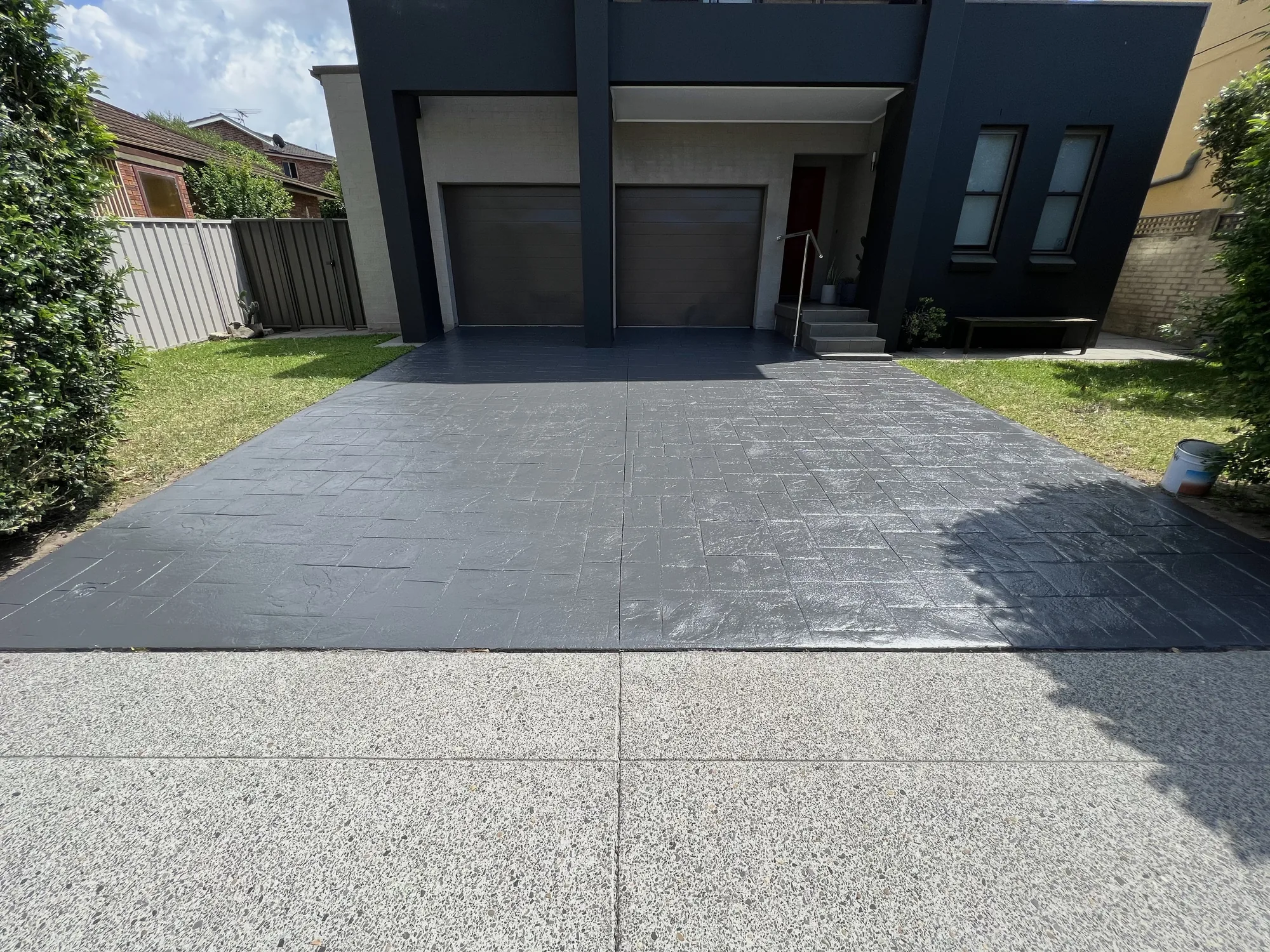 Stencil-pattern concrete driveway resealed in charcoal after coating, Sydney home