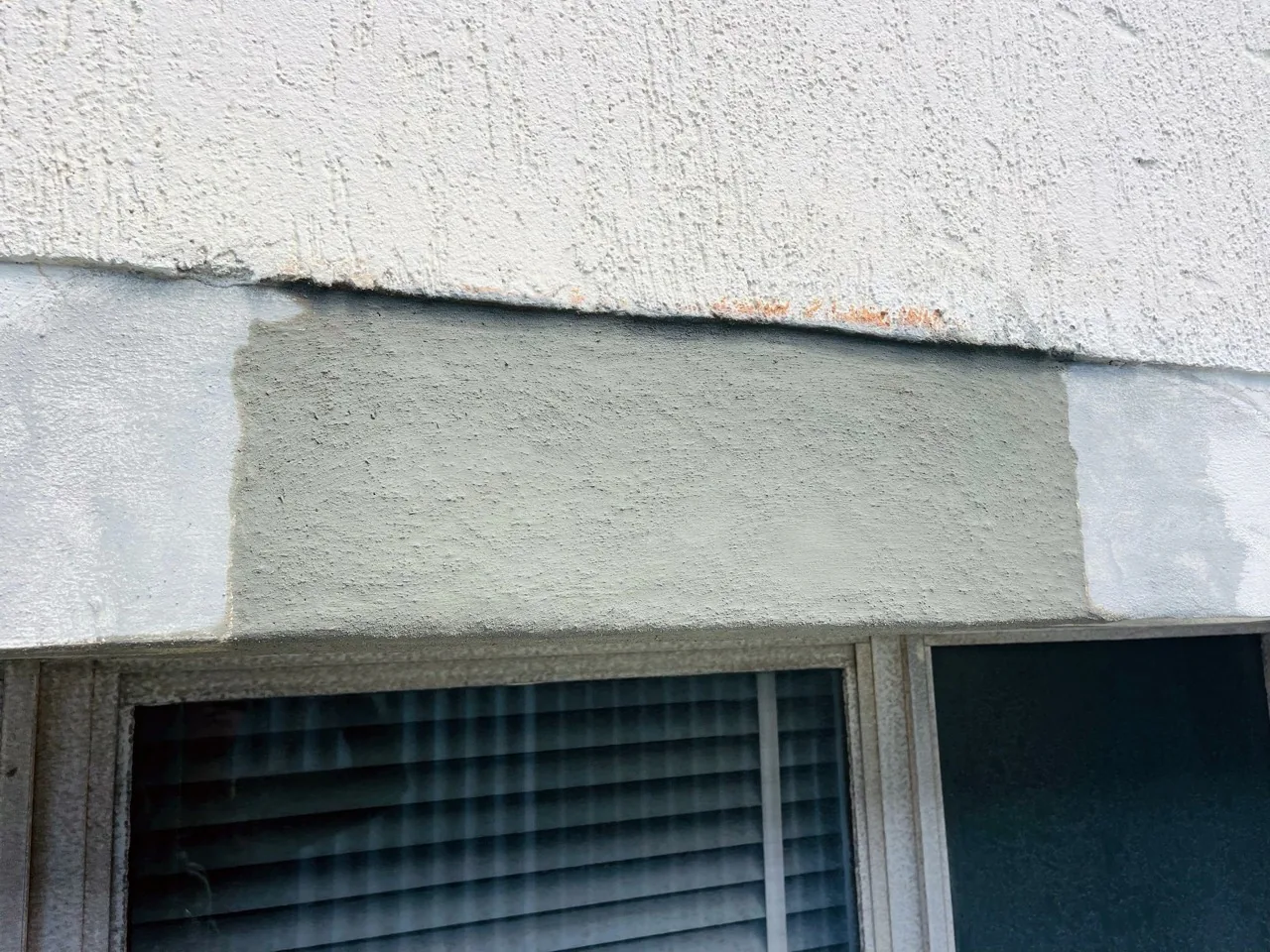 Window lintel re-rendered over treated reinforcement after concrete repair