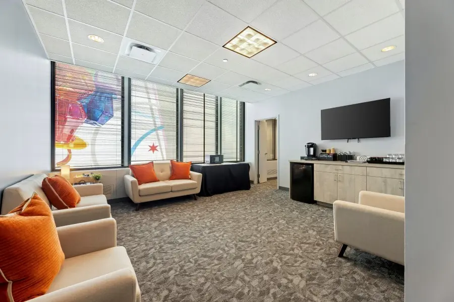 Stocked client observation lounge in the Windy City suite at L&E Research Chicago, featuring real-time HD digital audio and video feeds.