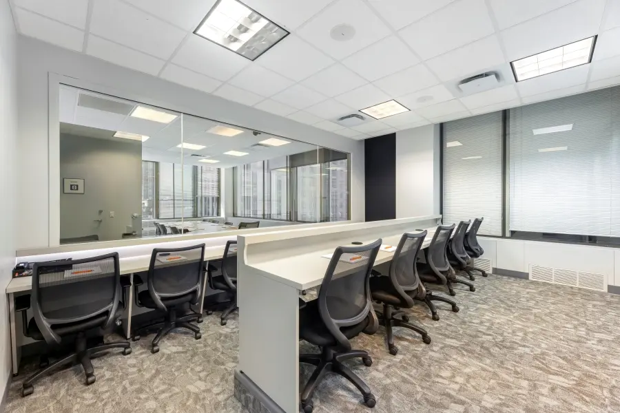 Comfortable client observation suite with a large one-way mirror overlooking the Millennium Park participant room at L&E Research Chicago.