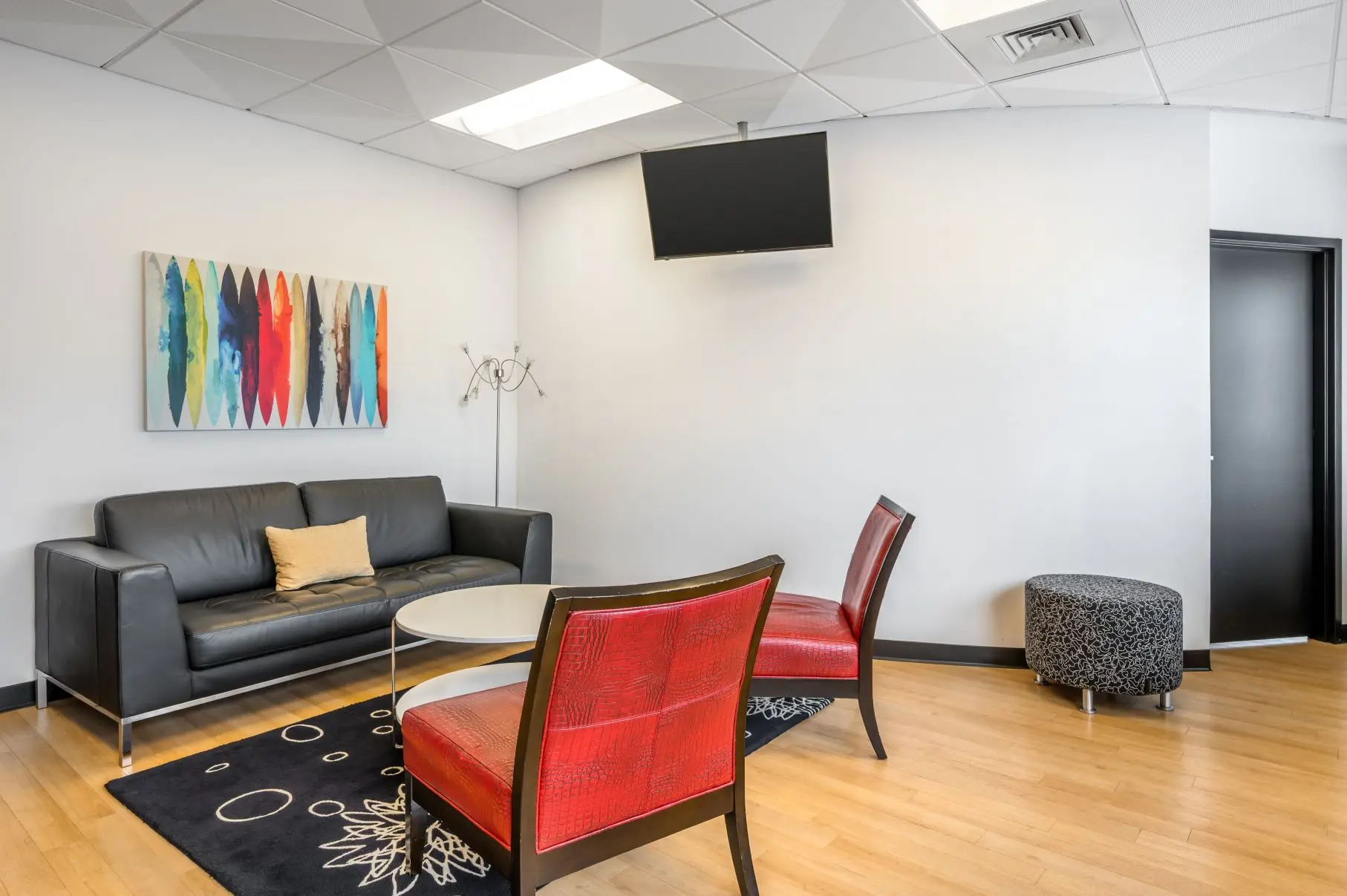 Private client observation area behind a large one-way mirror overlooking the creative Envisage ideation studio at L&E Research Cincinnati.