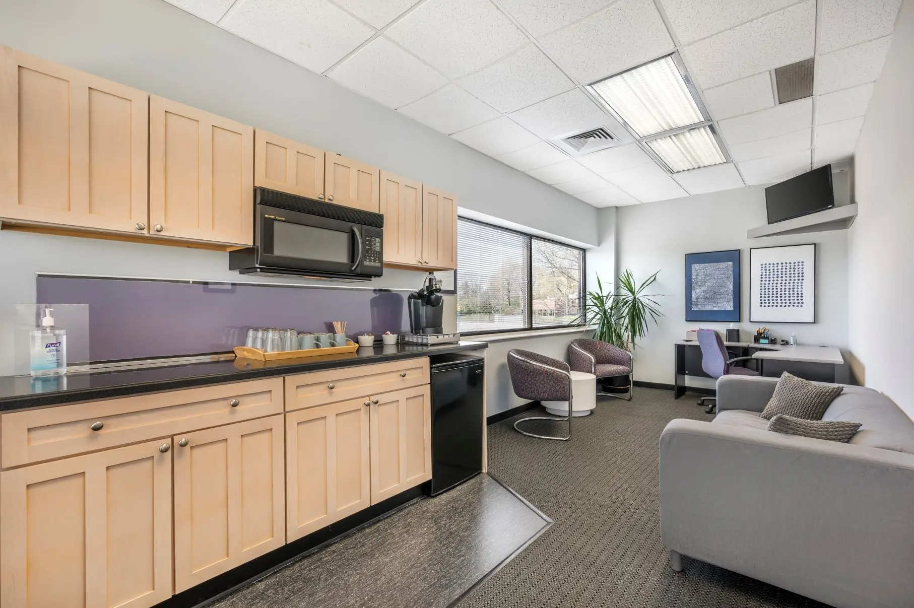 Stocked corporate client lounge in the Blue Ash focus group suite at L&E Research Cincinnati, featuring secure HD video streaming feeds.