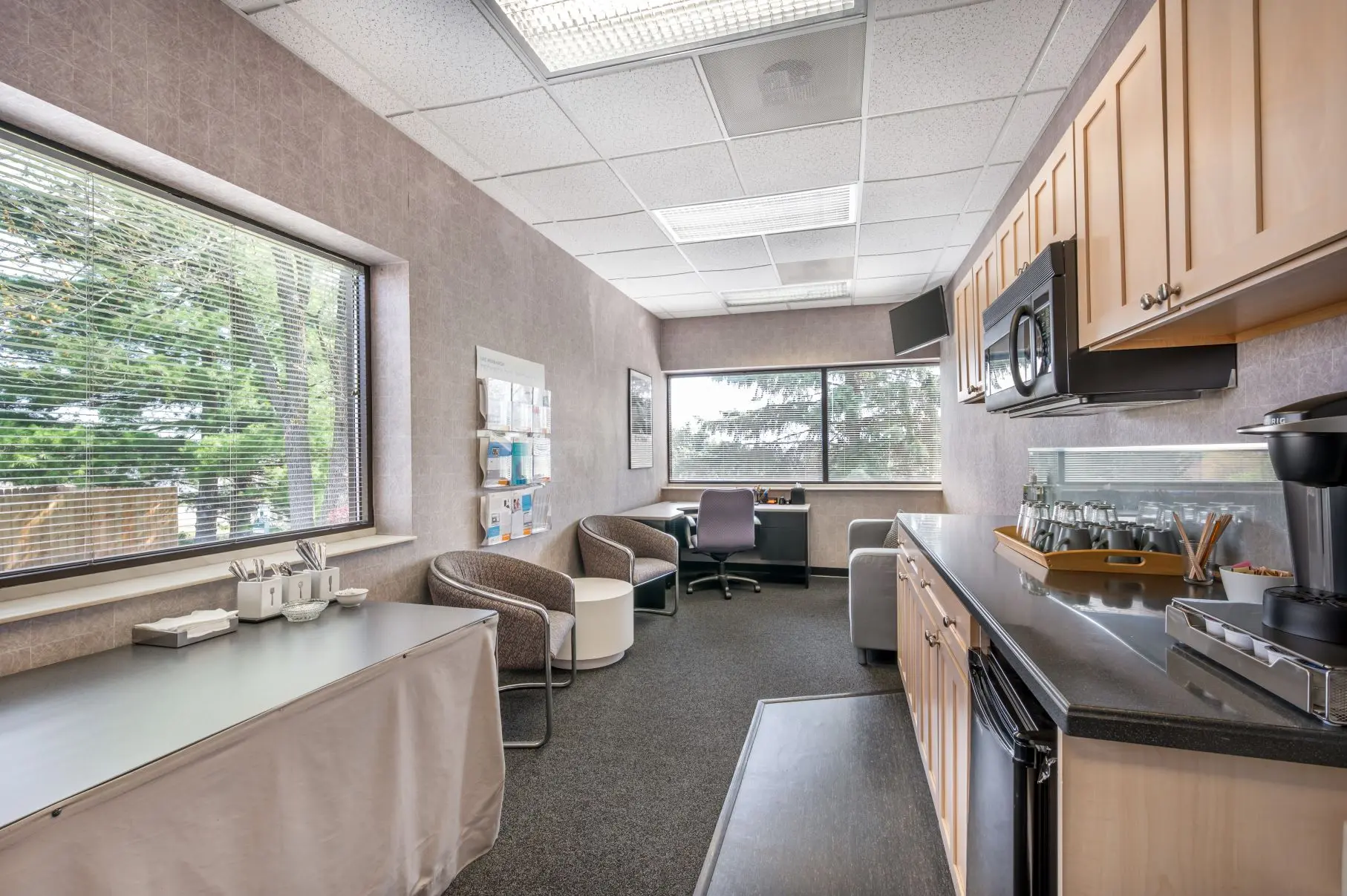 Comfortable private observer lounge in the Mt. Adams suite at L&E Research Cincinnati, equipped with workspace and digital streaming monitors.