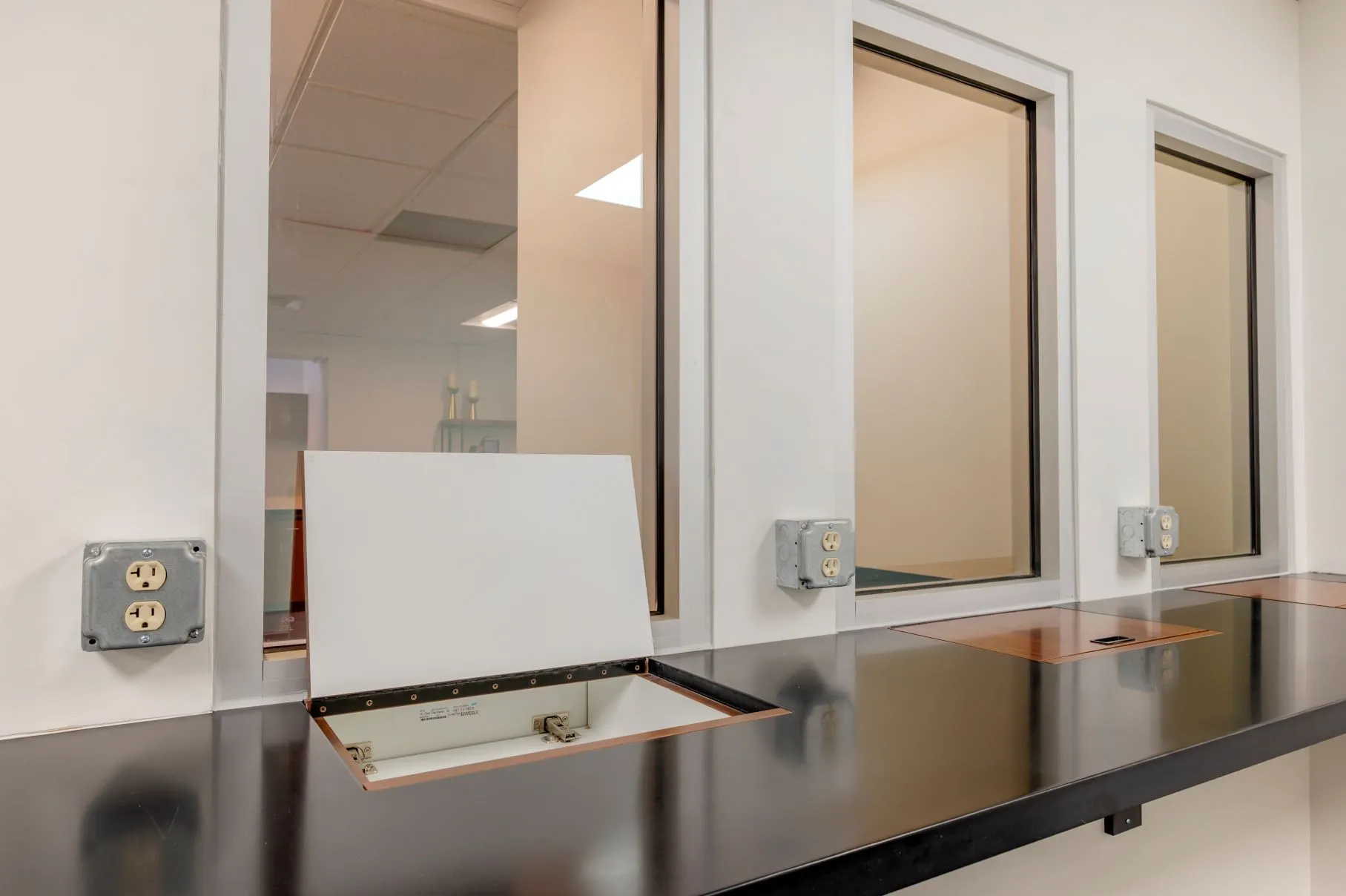 Adjacent premium observer seating with private built-in desk spaces inside the Queen City observation gallery at L&E Research.