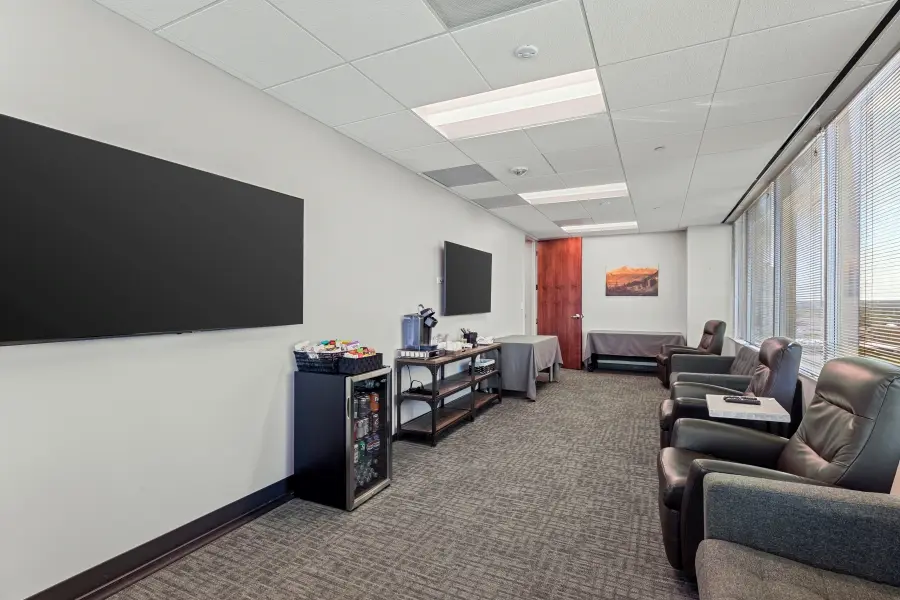 Stocked corporate client lounge in the Pikes Peak research suite at L&E Research Denver, featuring secure real-time HD video streaming feeds.