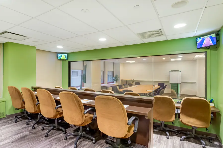 Spacious client observation room with tiered seating behind an expansive one-way mirror in the Central Park suite at L&E Research New York.