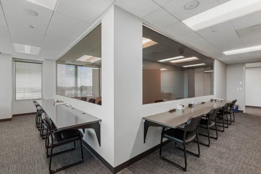 Comfortable client observation suite with tiered seating behind a large one-way mirror overlooking the Mile High participant room in Denver.