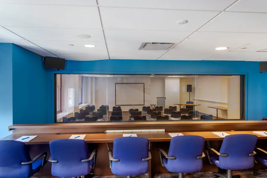 Spacious client observation room with tiered seating behind a large one-way mirror in the Midtown Manhattan Landmark suite at L&E Research.
