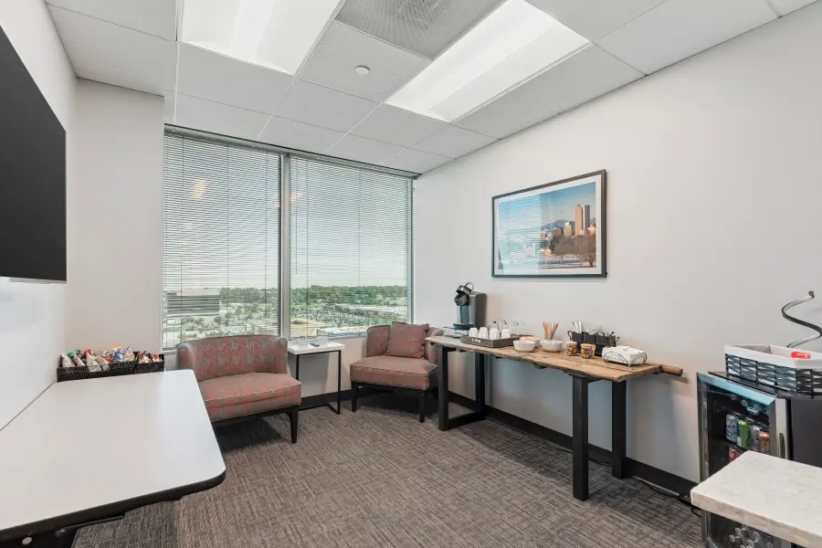 Modern executive client lounge in the Mile High suite at L&E Research Denver, equipped with private desks and HD streaming monitors.