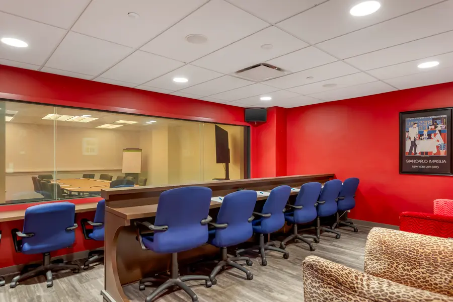 Dedicated observer viewing booth behind a large one-way mirror in the Broadway qualitative research suite at L&E Research New York.