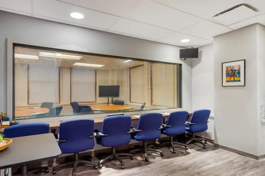 Discreet client viewing room behind a large one-way mirror overlooking the Wall Street suite participant panel at L&E Research New York.