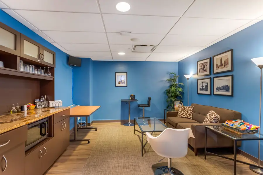 Premium corporate client lounge in the New York Landmark suite at L&E Research, featuring private workspaces and secure HD streaming monitors.