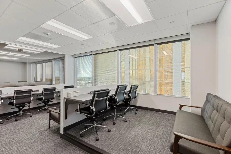 Standard client observation room behind a large one-way mirror overlooking the Vail suite participant panel at L&E Research Denver.
