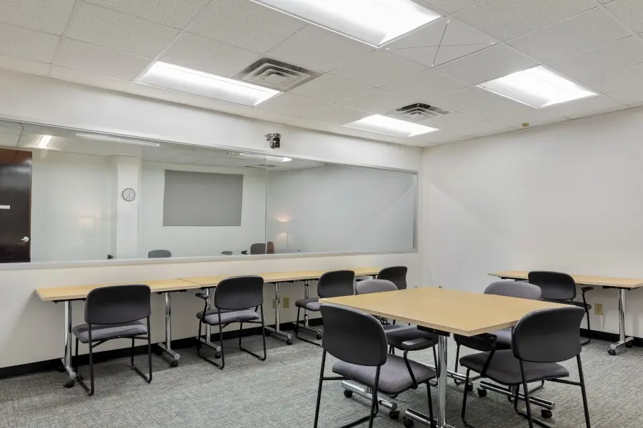 Qualitative research room inside the Raleigh Pinehurst suite, arranged with modular tables for intimate consumer or medical interviews.