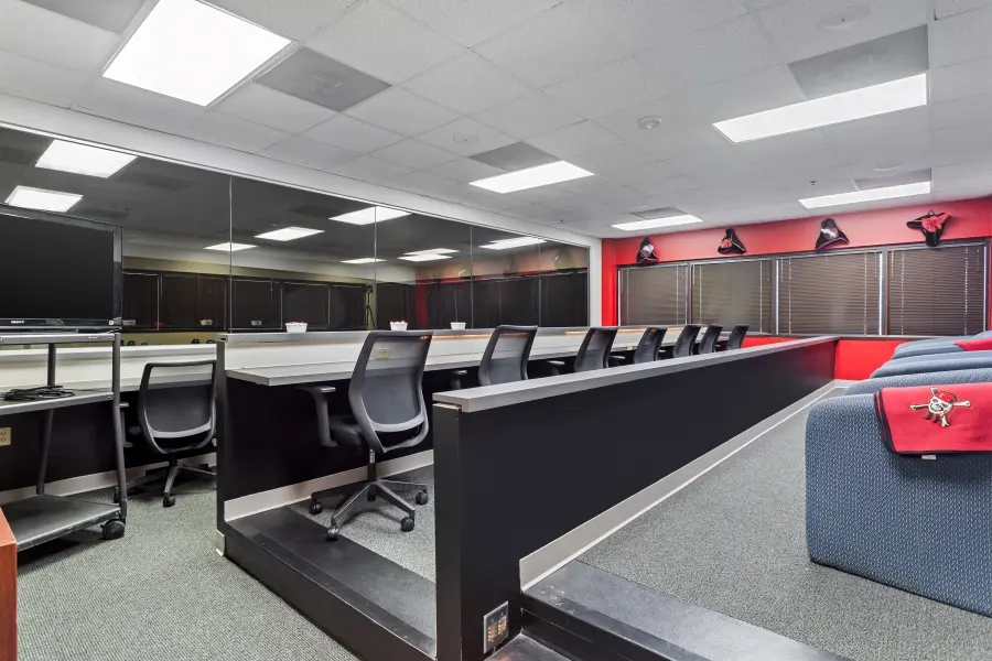 Spacious client observation room with tiered seating behind a large one-way mirror in the Tampa Bay focus group suite at L&E Research.