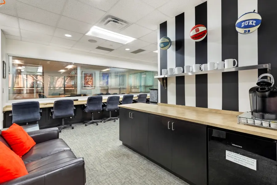 Combined client observation and viewing lounge suite in the Carolina room at L&E Research Raleigh, equipped with workspace and HD video monitors.