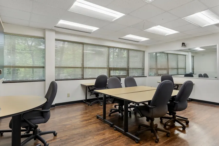 Large focus group room within the Hatteras suite at L&E Research Raleigh, configured as a mock jury room layout for sample jury studies.