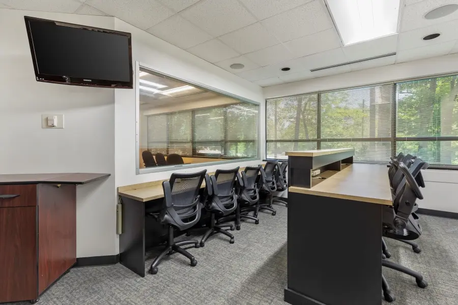 Discreet client viewing booth behind an expansive one-way mirror in the Hatteras focus group suite at L&E Research Raleigh.