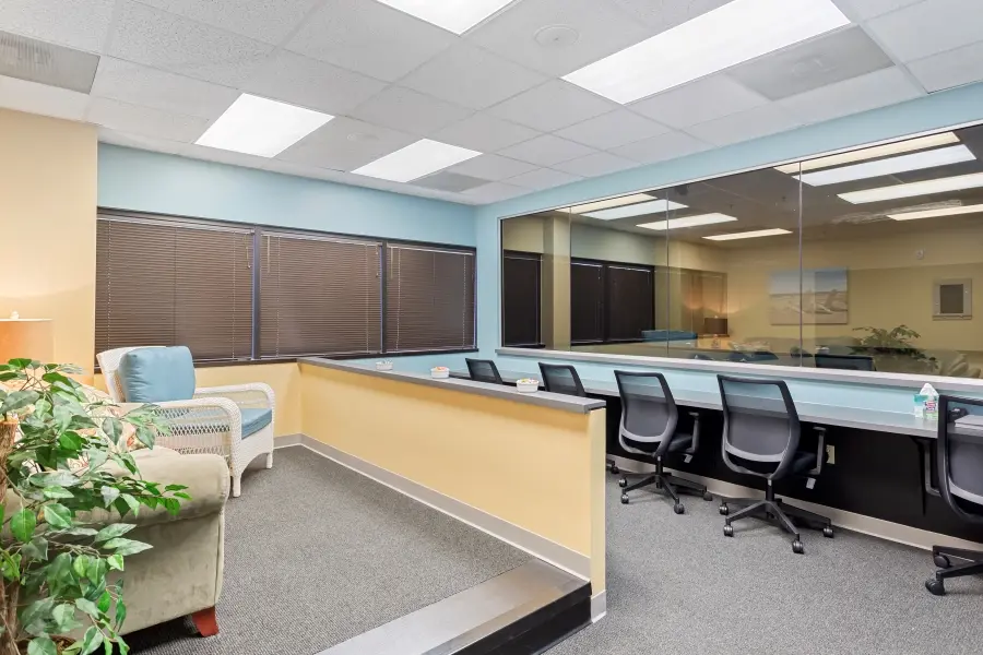 Discreet client viewing room behind an expansive one-way mirror in the Clearwater focus group suite at L&E Research Tampa.
