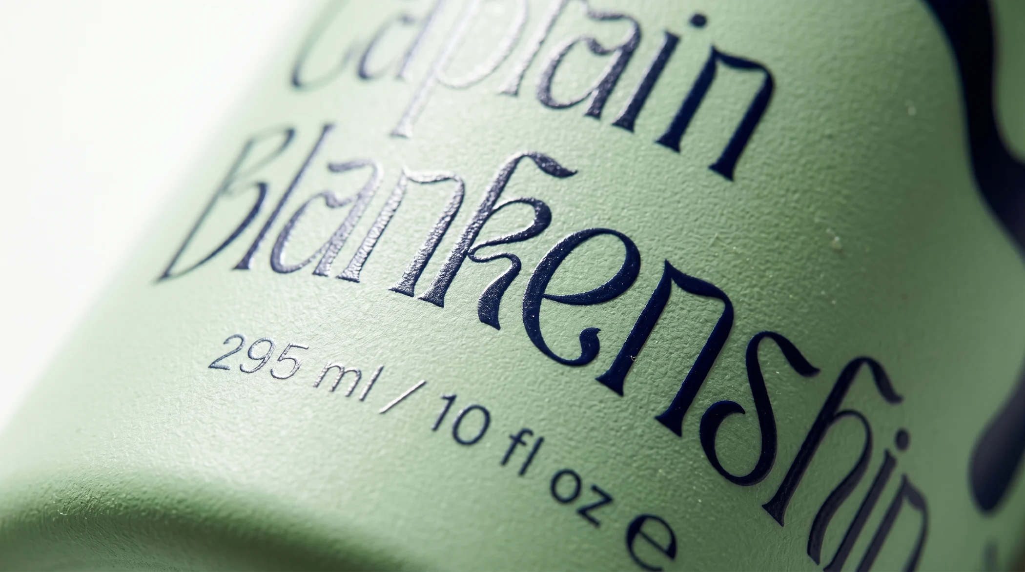 Close-up of a light green bottle label with the brand name 'Captain Blankenship' and volume 295 ml/10 fl oz.