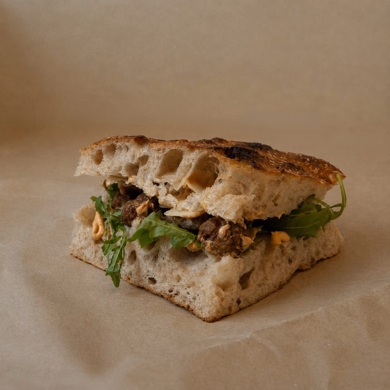 "En Spicy Tony" sandwich - Oksekødboller med tomat og sucuk, parmesanflager, tomatmayo med bagt hvidløg, chipotlemayo, grillet aubergine og rucola.
