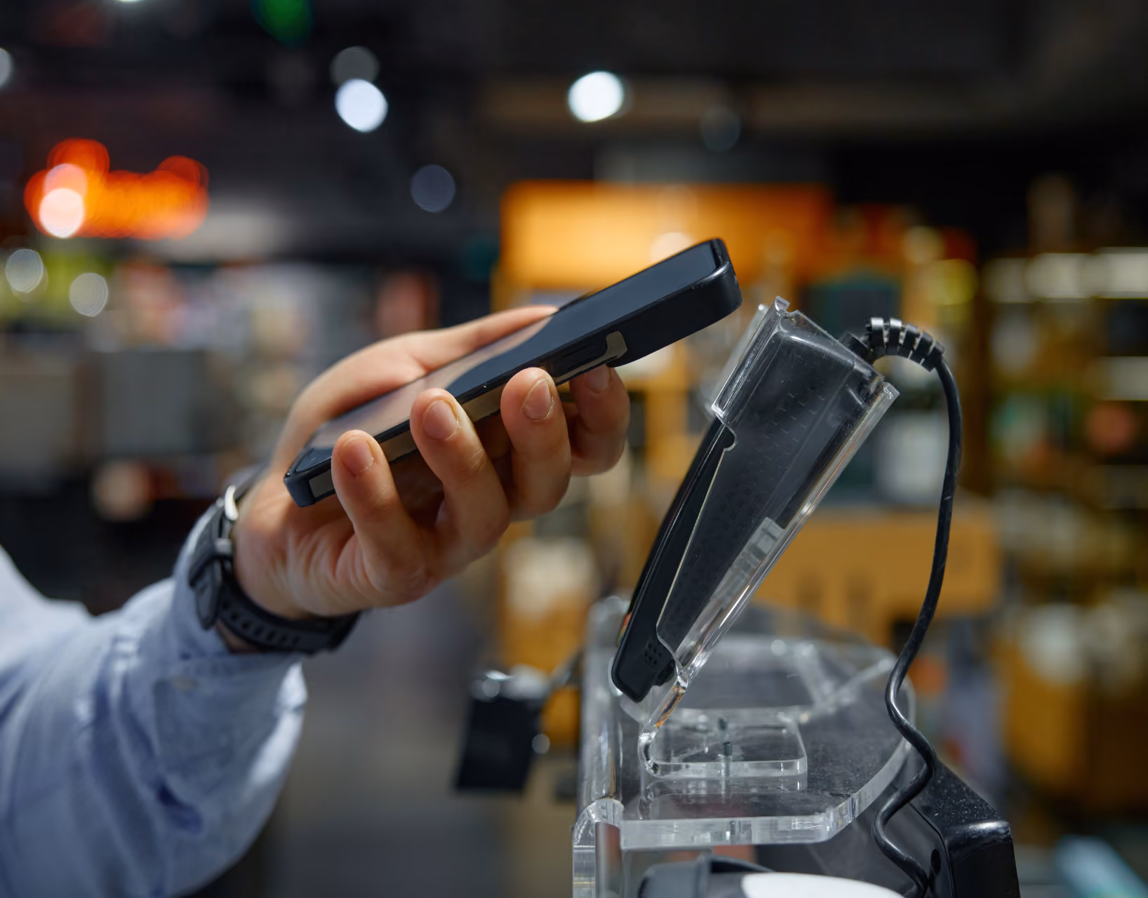 Customer tapping a phone on a card reader at a supply counter