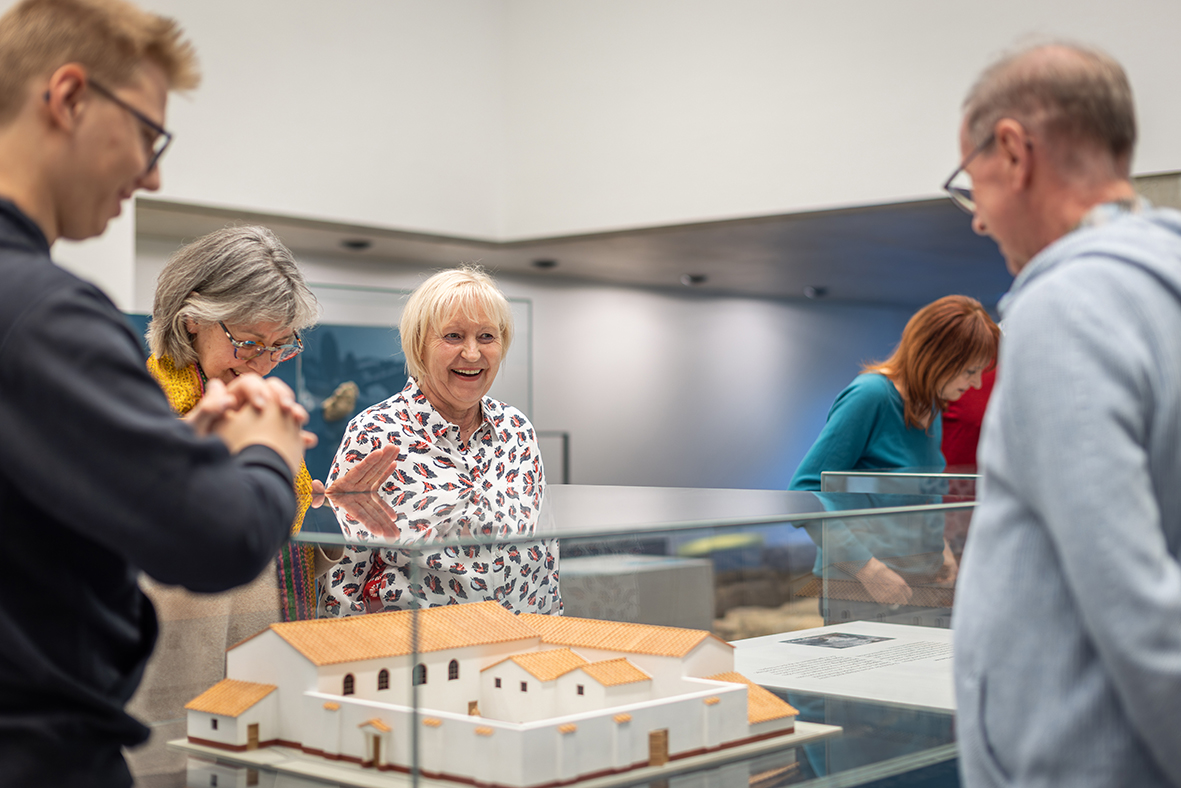 Gruppe von Besucherinnen und Besuchern an einer Vitrine