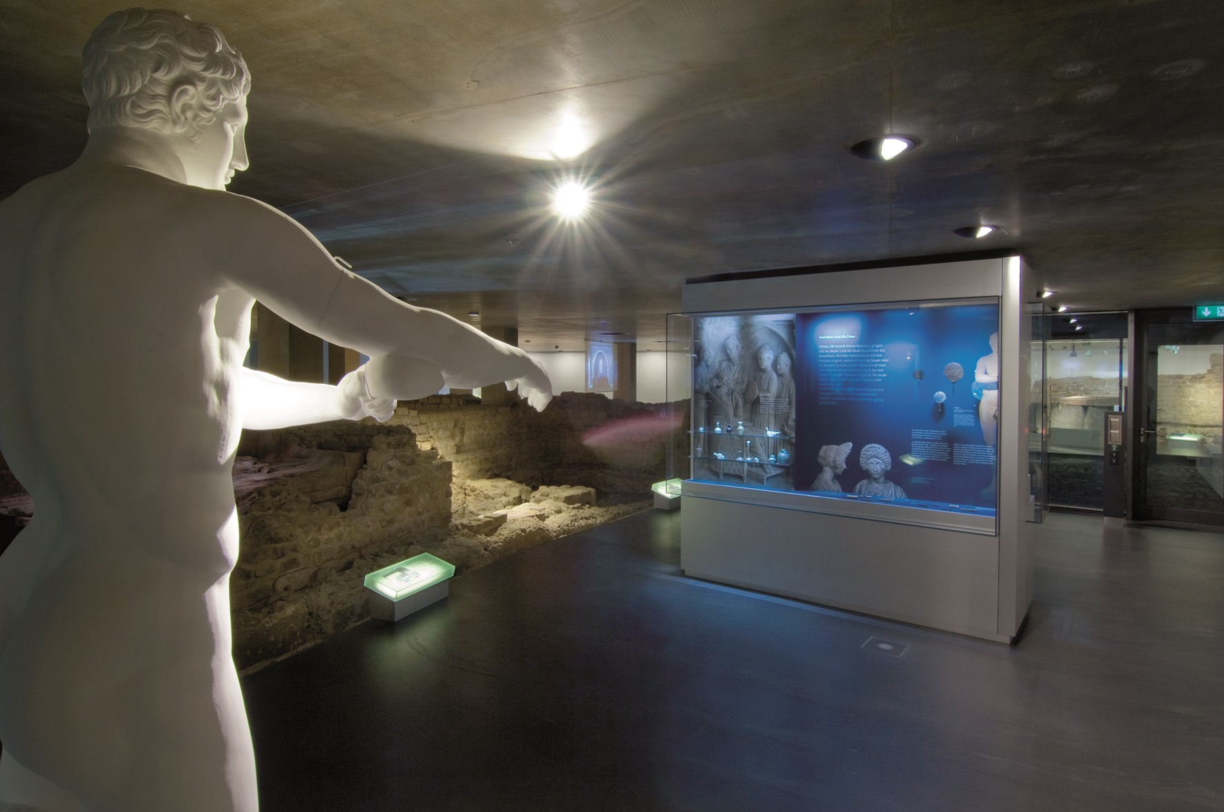 Blick in die Dauerausstellung der Römerthermen Zülpich mit römischer Statue und Medienstation