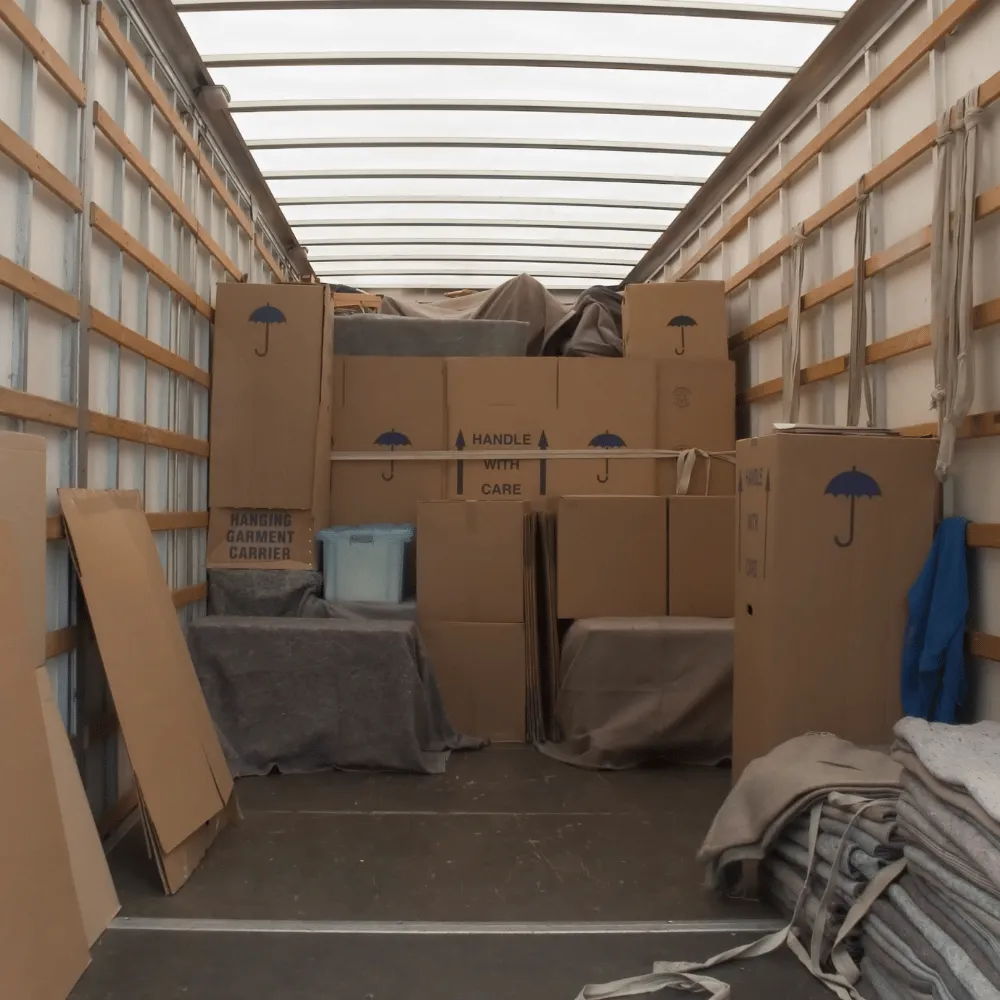 Umzugskartons und Möbel stehen im Laderaum eines Transporters