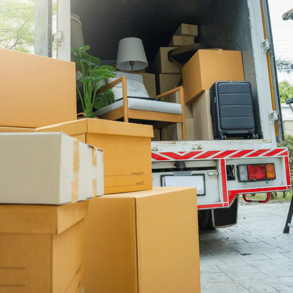 Umzugskartons und verpackte Möbel im Laderaum eines Transporters