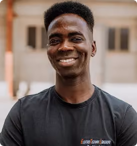 Fröhlicher junger Mann mit kurzem Afrohaar und schwarzem T-Shirt lächelt in die Kamera.