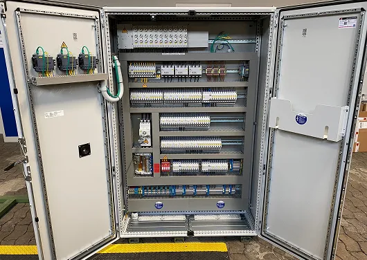 Offenes Schaltschrankgehäuse mit mehreren Reihen von elektrischen Sicherungen und Verdrahtung.