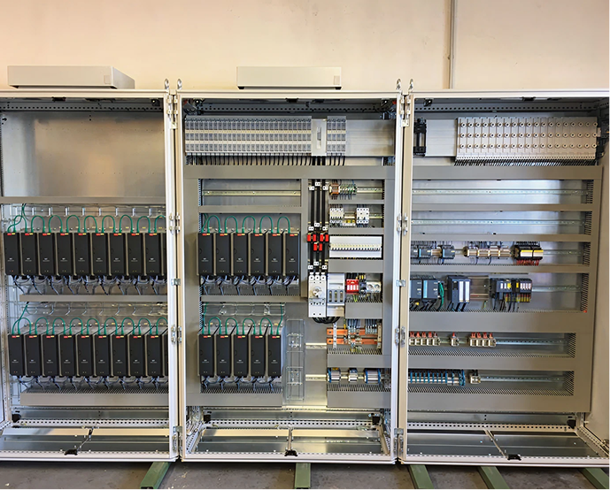 Offenes technisches Schaltschrankgehäuse mit zahlreichen Steuerungen, Relais und Elektronikmodulen.