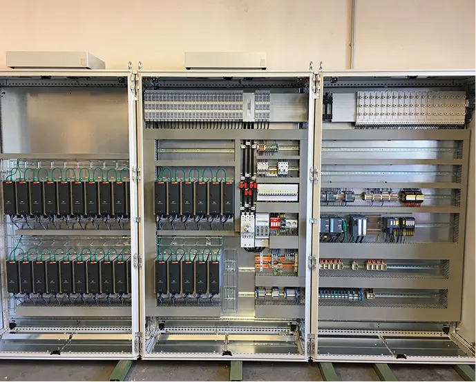 Offenes technisches Schaltschrankgehäuse mit zahlreichen Steuerungen, Relais und Elektronikmodulen.