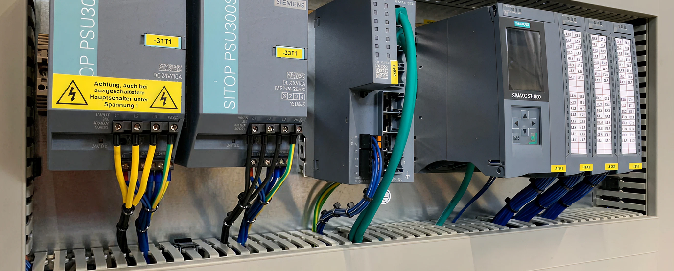 Industrielles Steuerungspanel mit Siemens SITOP PSU300S Netzteilen und SIMATIC S7-500 Automatisierungsmodul.