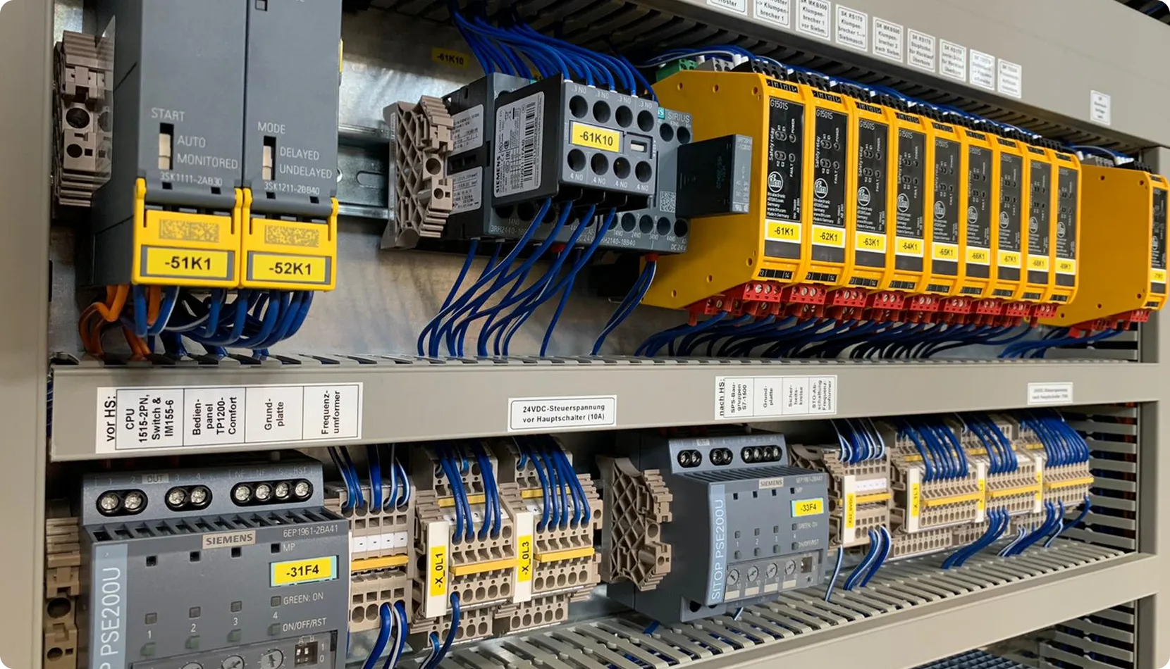 Steuerungspanel mit Siemens-Komponenten, Relais, und Kabelanschlüssen geordnet in einer Schaltanlage.