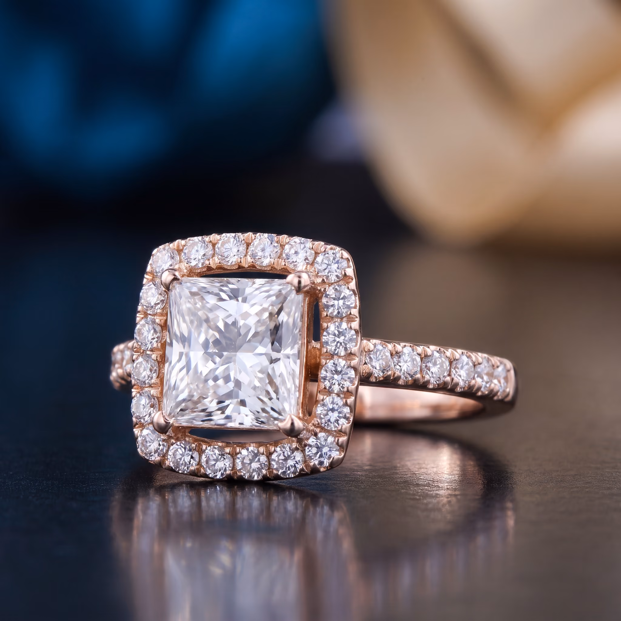 Rose gold ring with a large square center diamond and smaller diamonds encircling it and along the band.