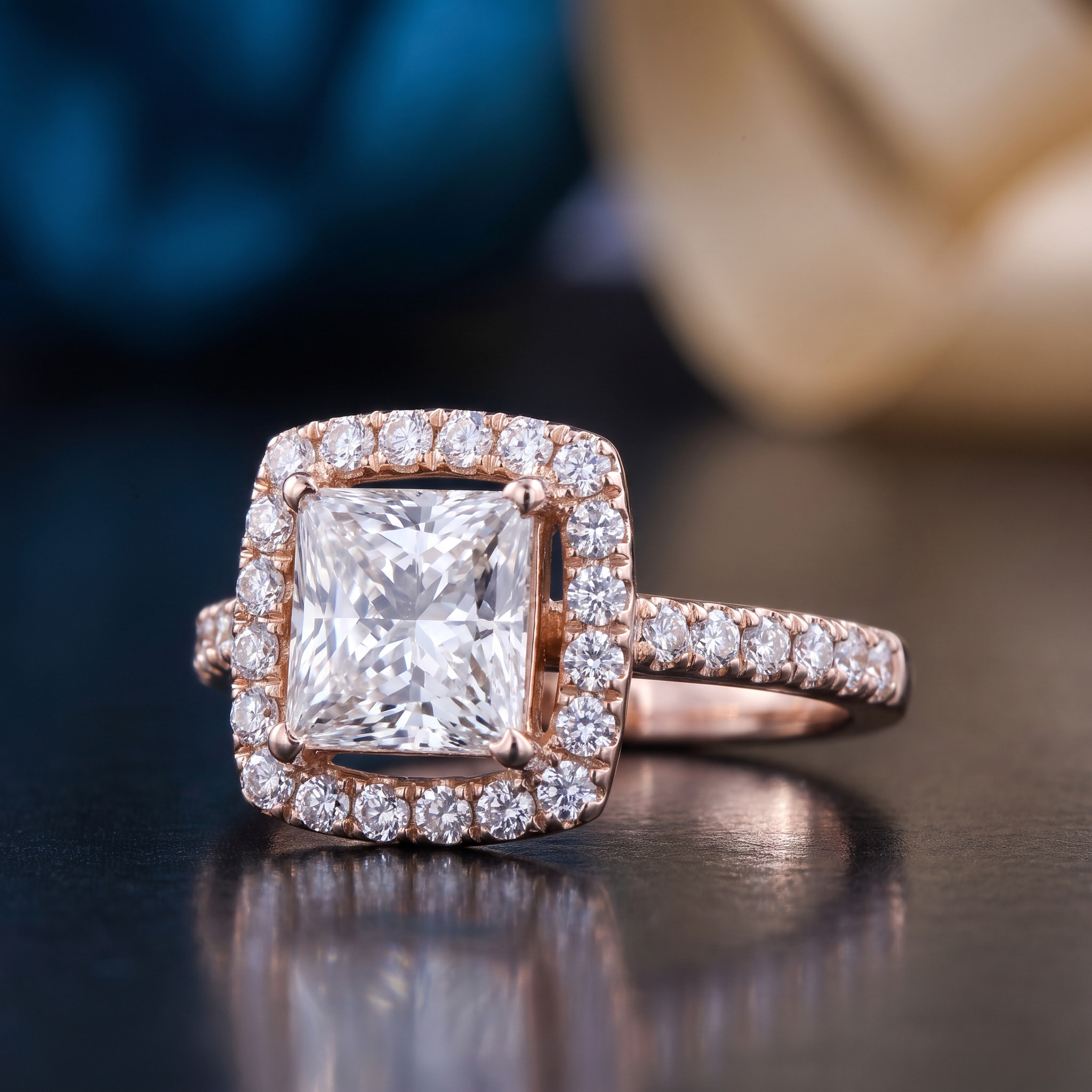 Rose gold ring with a large square center diamond and smaller diamonds encircling it and along the band.